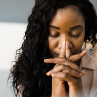 woman praying with her eyes closed